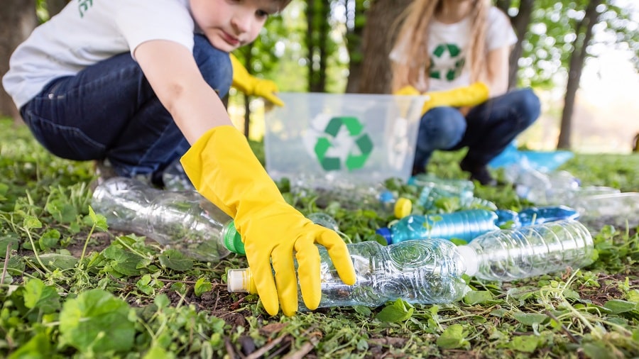 ragazzo-e-ragazza-alla-raccolta-dei-rifiuti-di-plastica-in-un-parco-min